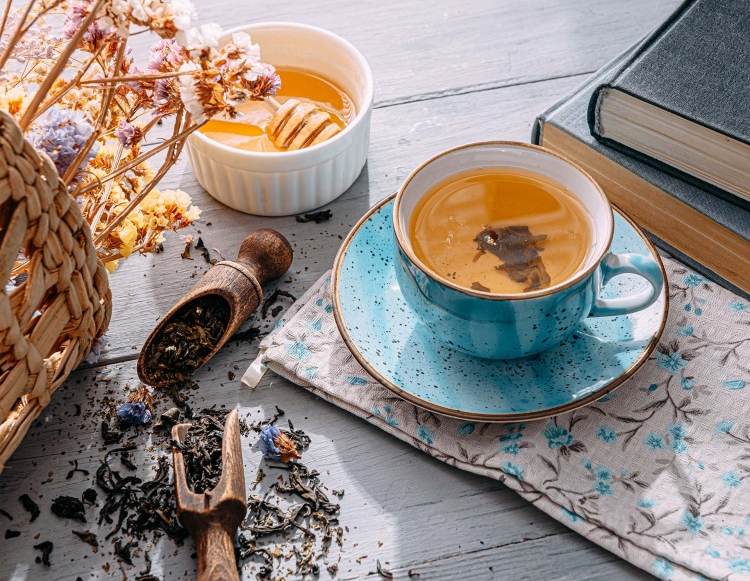 Tasse de thé sur une table avec du thé en vrac et un bouquet de fleurs de pintemps